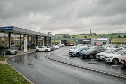Vue panoramique de concessionnaires automobiles en Normandie avec showrooms modernes et véhicules exposés