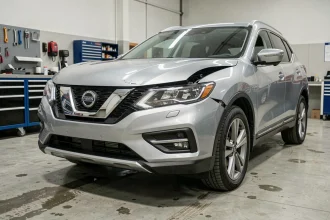 Vue avant d'un SUV moderne montrant les zones de déformation et les phares dans un atelier automobile